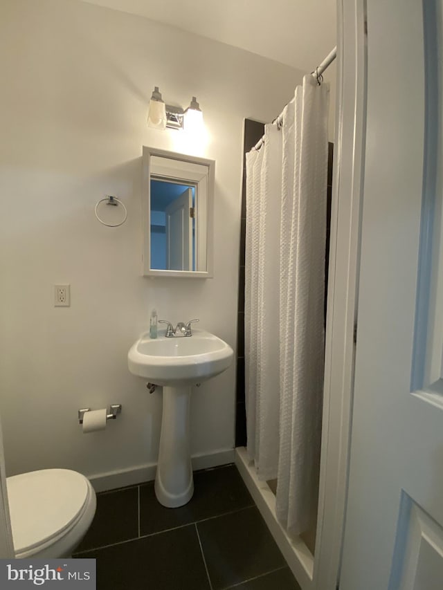 bathroom featuring tile patterned floors, a shower with shower curtain, and toilet