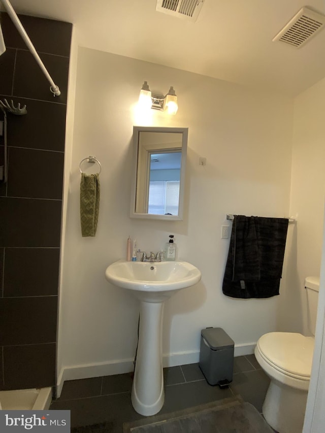 bathroom with toilet and tile patterned floors