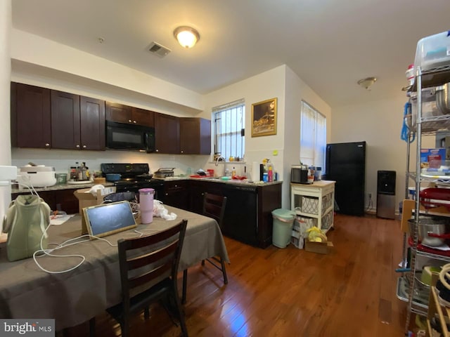 kitchen with black appliances, dark hardwood / wood-style flooring, and dark brown cabinetry