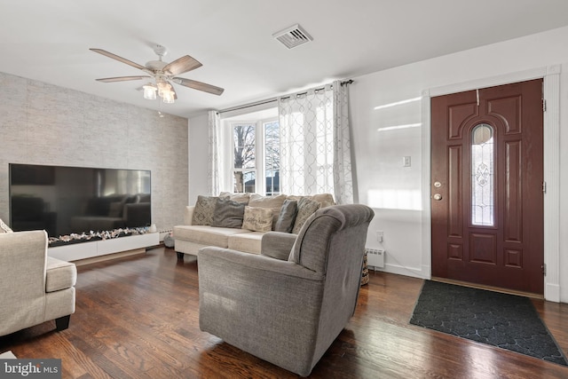 living room featuring dark hardwood / wood-style flooring and ceiling fan