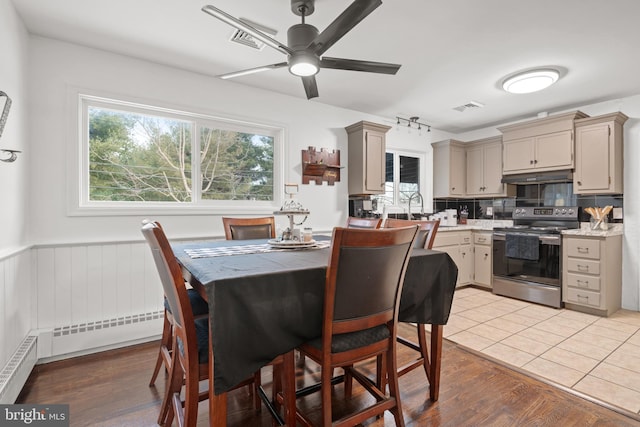 dining room featuring light wood-type flooring, ceiling fan, and sink