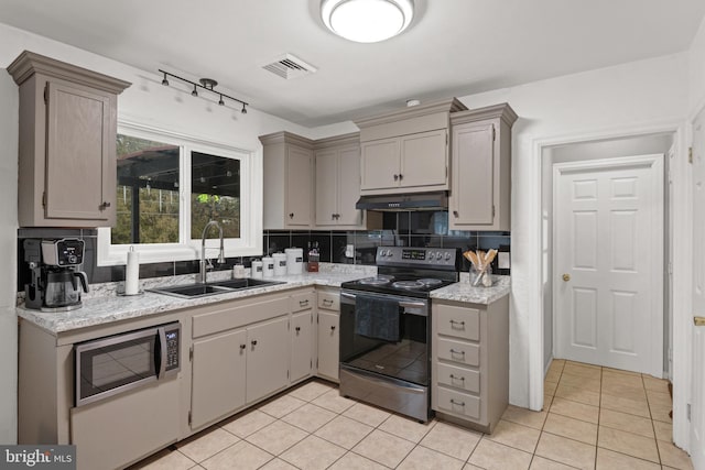 kitchen with sink, backsplash, gray cabinets, light tile patterned floors, and appliances with stainless steel finishes