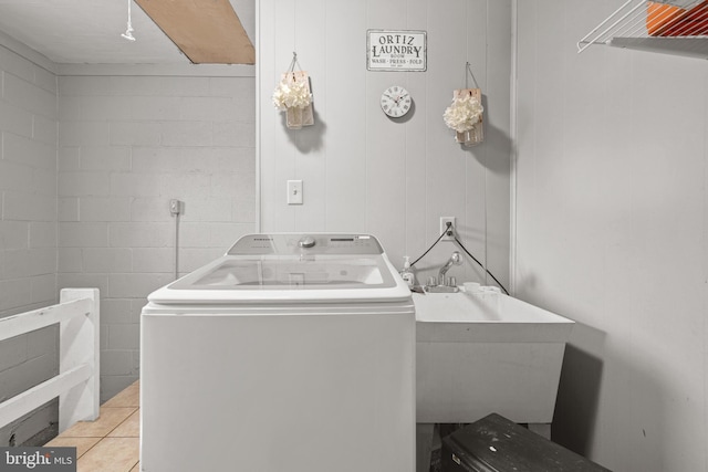 washroom with washer / dryer, light tile patterned floors, and sink