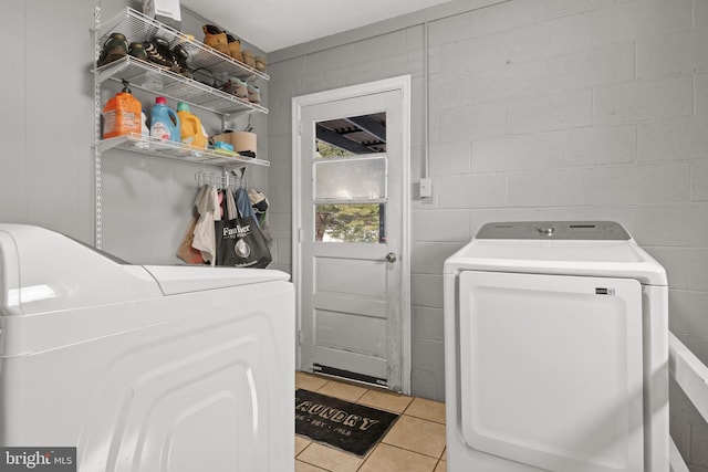 laundry area with light tile patterned flooring and washing machine and clothes dryer