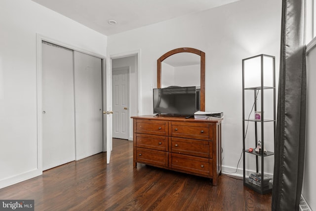 bedroom featuring dark wood-type flooring and a closet