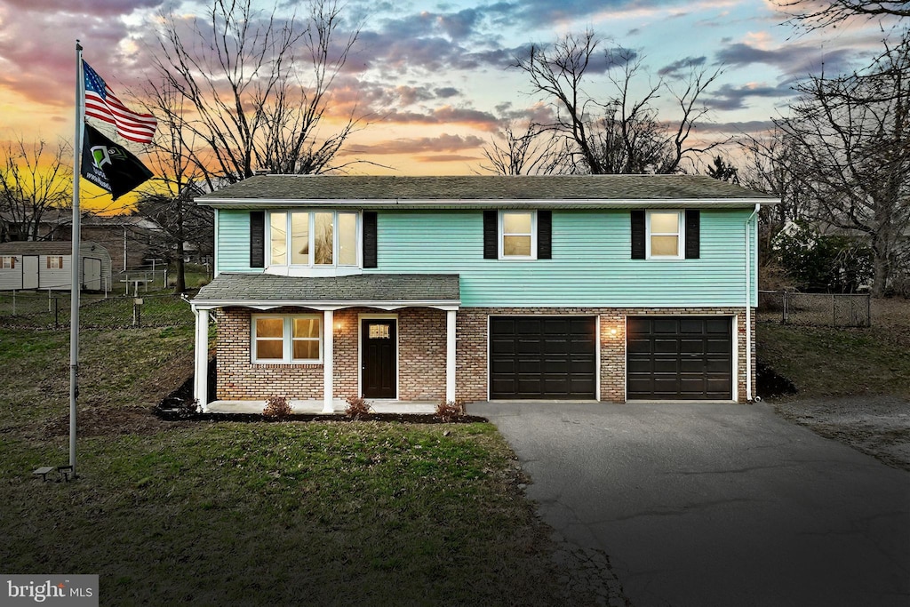 view of front of property featuring a lawn and a garage