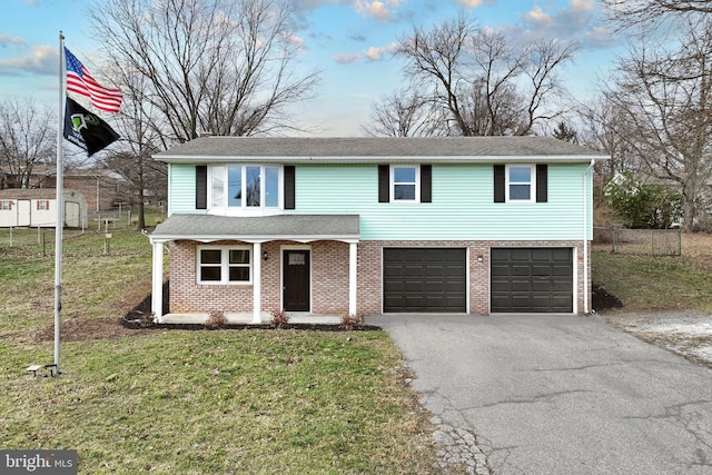 view of front of house with a porch, a garage, and a front lawn