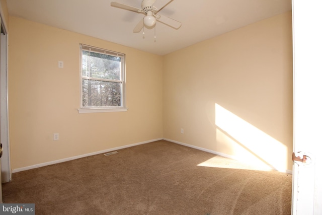 carpeted spare room with ceiling fan