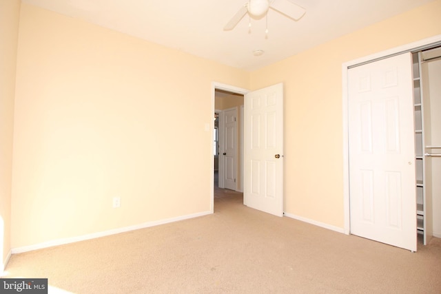 unfurnished bedroom featuring ceiling fan, a closet, and carpet