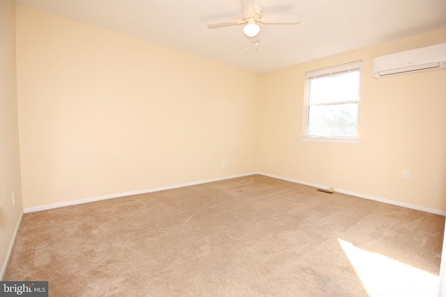 empty room featuring ceiling fan, light carpet, and a wall mounted AC