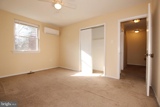 unfurnished bedroom featuring light carpet, a closet, a wall unit AC, and ceiling fan