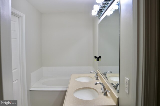 bathroom with a tub and vanity