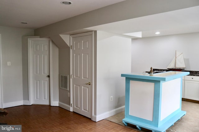 bar with white cabinetry and parquet flooring