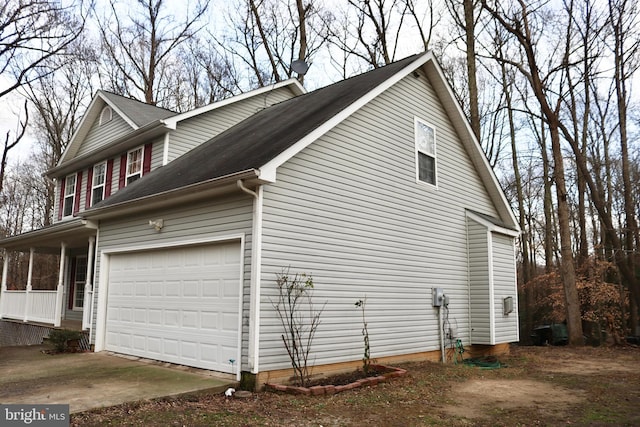 view of side of property featuring covered porch and a garage