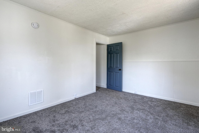 carpeted spare room featuring baseboards, visible vents, and a textured ceiling