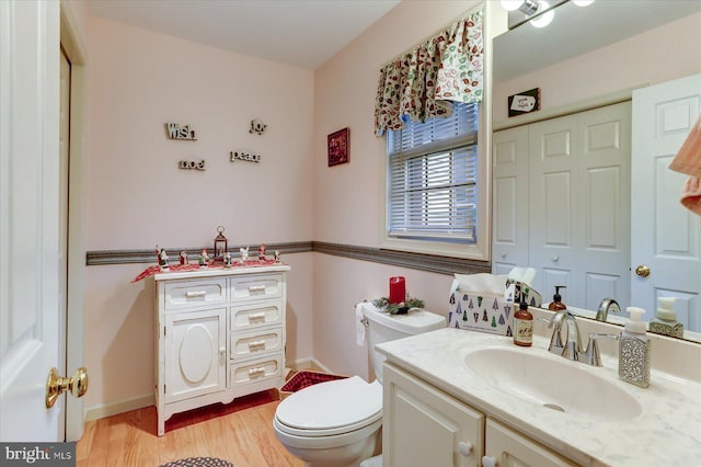 bathroom featuring vanity, hardwood / wood-style flooring, and toilet