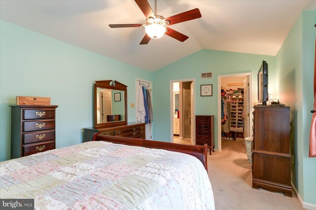 carpeted bedroom featuring ensuite bath, vaulted ceiling, ceiling fan, a spacious closet, and a closet