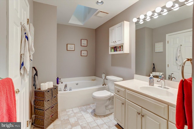 bathroom with a tub to relax in, vanity, a skylight, and toilet