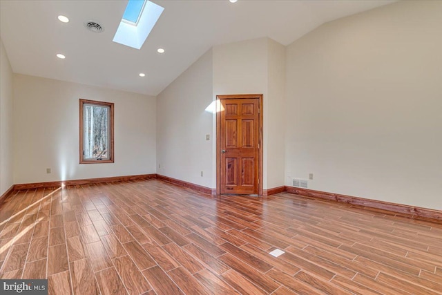 spare room featuring lofted ceiling with skylight