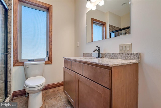 bathroom featuring vanity, a healthy amount of sunlight, an enclosed shower, and toilet