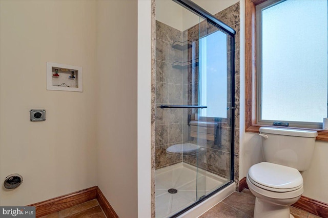 bathroom featuring tile patterned flooring, toilet, and an enclosed shower