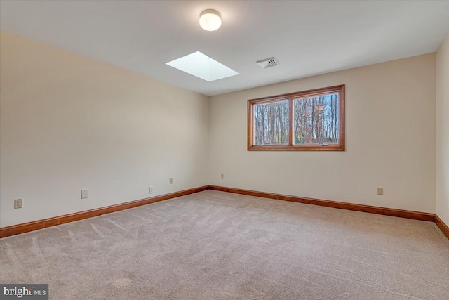 carpeted spare room with a skylight