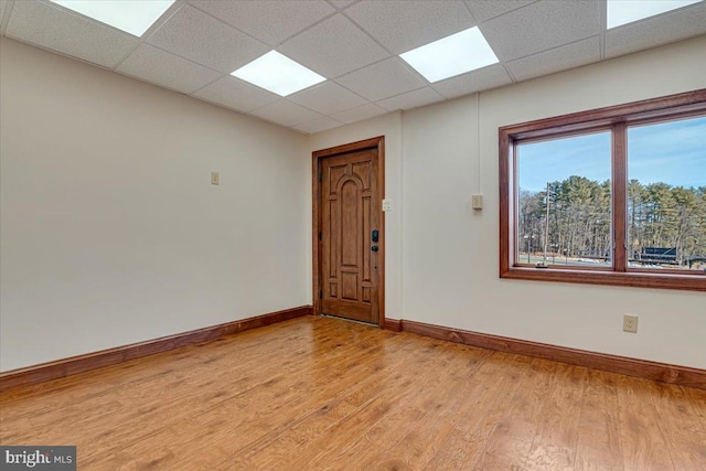 spare room with a paneled ceiling and light hardwood / wood-style floors