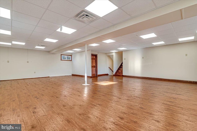 empty room featuring a paneled ceiling and hardwood / wood-style floors