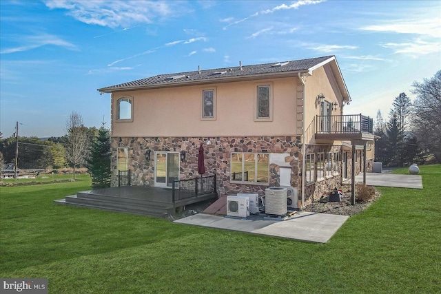 rear view of house with a lawn, central air condition unit, a patio, and a deck