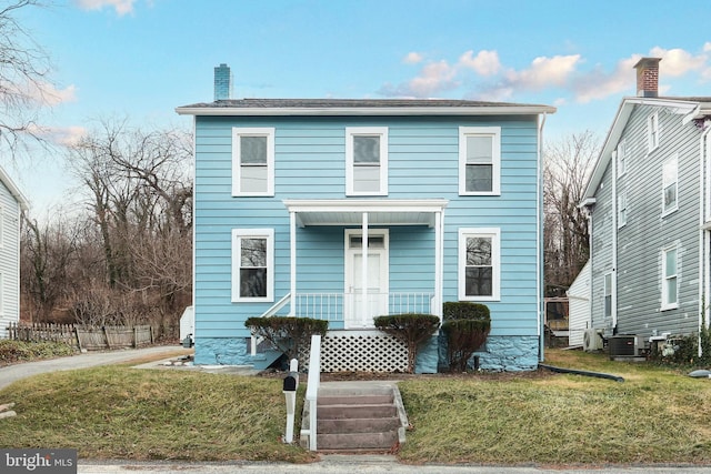 view of front property featuring cooling unit and a front yard