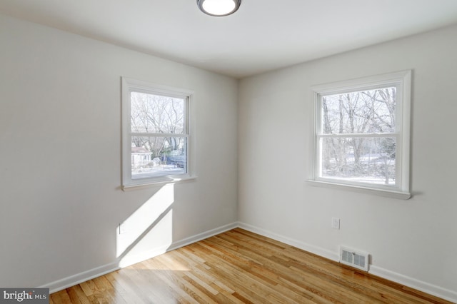 unfurnished room with plenty of natural light and light hardwood / wood-style floors