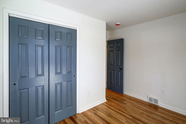 unfurnished bedroom featuring a closet and wood-type flooring