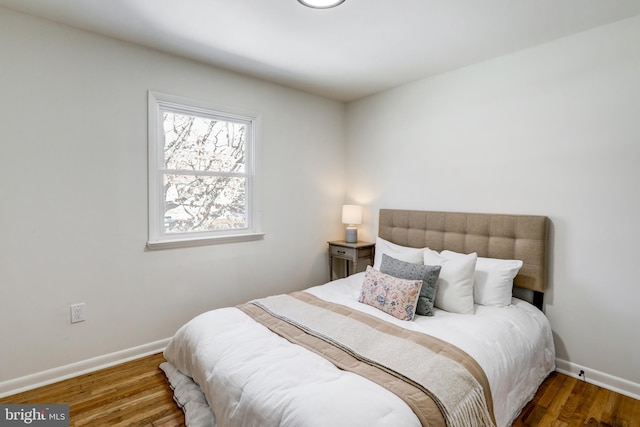 bedroom with dark hardwood / wood-style floors