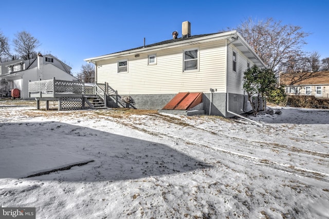 snow covered house featuring a deck