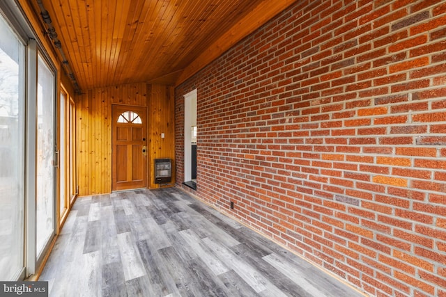 unfurnished sunroom with heating unit, plenty of natural light, wood ceiling, and lofted ceiling