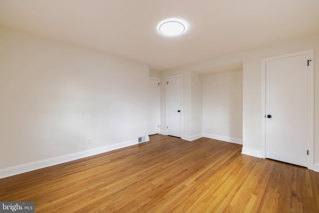 spare room featuring wood-type flooring