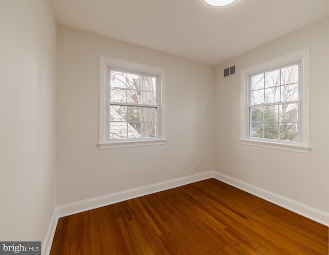 spare room featuring hardwood / wood-style flooring and plenty of natural light