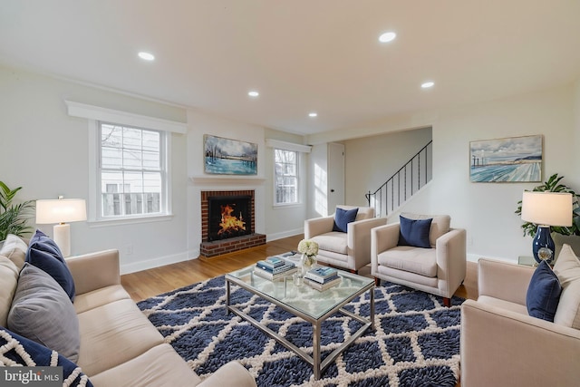 living room with a fireplace, wood-type flooring, and a healthy amount of sunlight