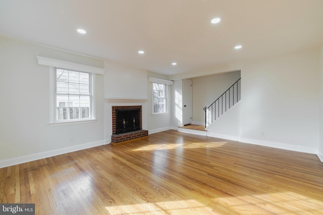 unfurnished living room with a fireplace and light hardwood / wood-style flooring