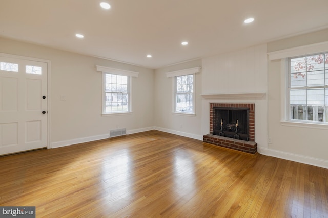 unfurnished living room featuring a fireplace and light hardwood / wood-style flooring