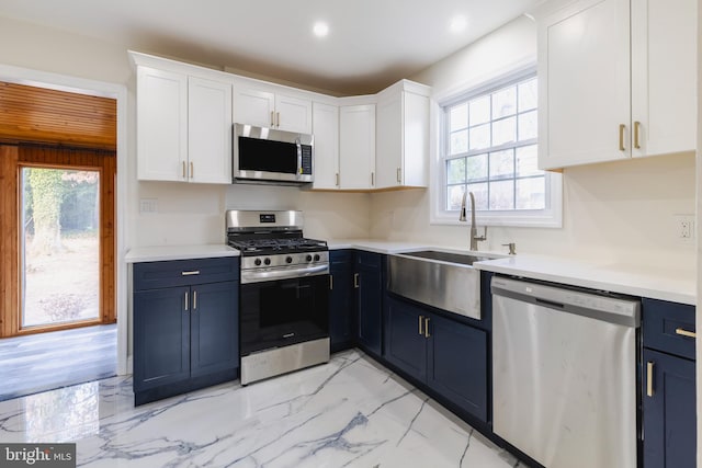 kitchen featuring blue cabinetry, appliances with stainless steel finishes, and white cabinetry