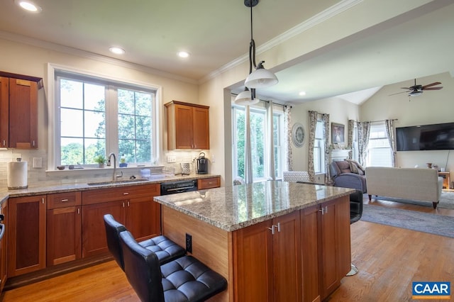 kitchen with decorative backsplash, decorative light fixtures, light hardwood / wood-style floors, and sink