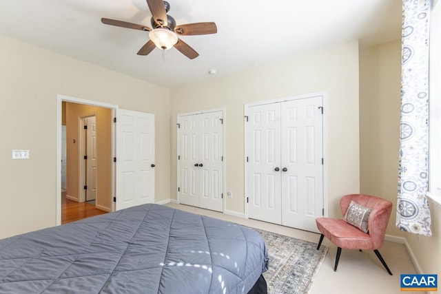 bedroom featuring ceiling fan and two closets