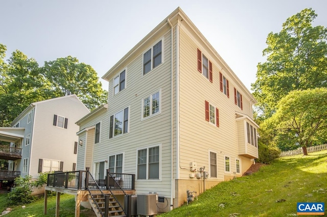 back of house with a wooden deck, a yard, and central AC unit