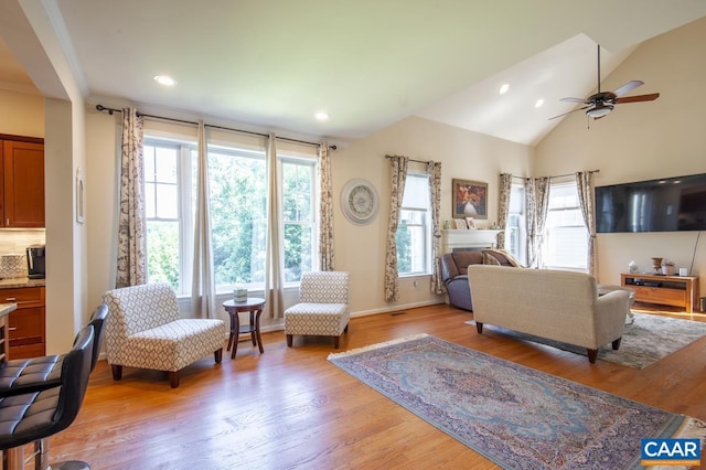 living room with light hardwood / wood-style flooring, plenty of natural light, lofted ceiling, and ceiling fan