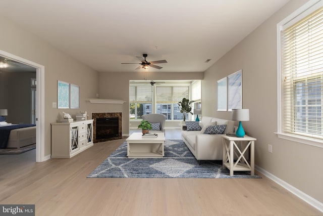 living room featuring plenty of natural light, light hardwood / wood-style floors, and a high end fireplace