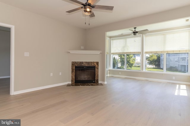 unfurnished living room with a fireplace, light hardwood / wood-style floors, and ceiling fan