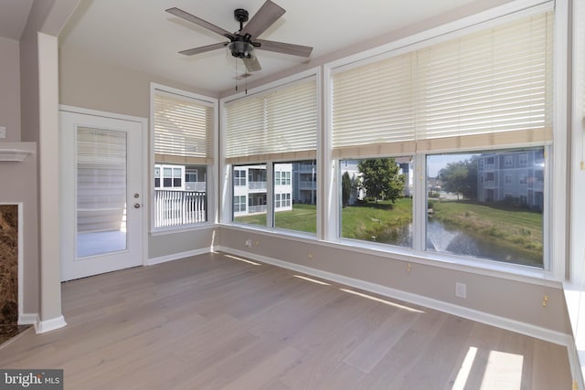 unfurnished sunroom with ceiling fan