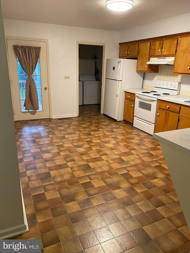 kitchen with washer and dryer, white appliances, and tasteful backsplash