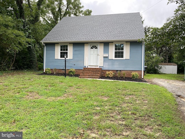 view of front of property with a storage unit and a front lawn